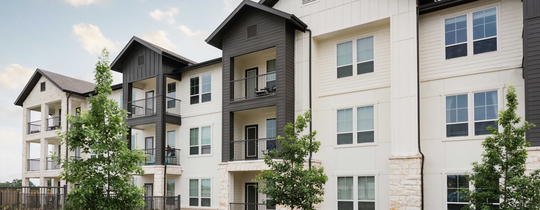 Elegant interior lounge area at 1846 Apartments, Fredericksburg, TX, with modern seating, warm lighting, large windows, and stylish decor in a spacious setting.