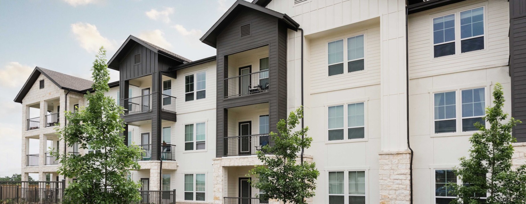 Elegant interior lounge area at 1846 Apartments, Fredericksburg, TX, with modern seating, warm lighting, large windows, and stylish decor in a spacious setting.
