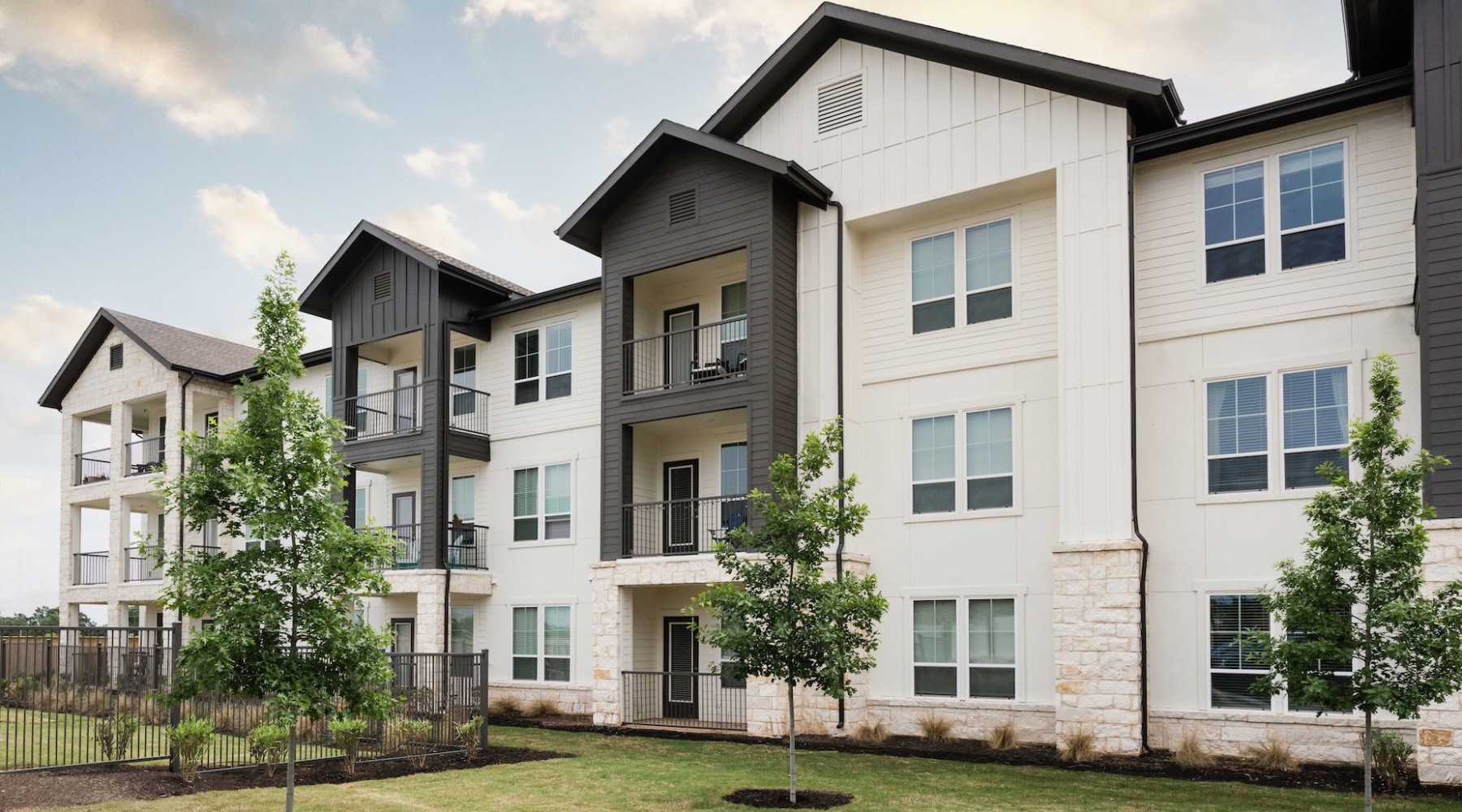 Elegant interior lounge area at 1846 Apartments, Fredericksburg, TX, with modern seating, warm lighting, large windows, and stylish decor in a spacious setting.